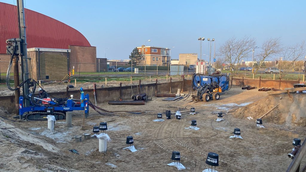 Bohrpfahlgründung mit Bohrgerät und frisch installierten Betonpfählen auf Gewerbebaustelle